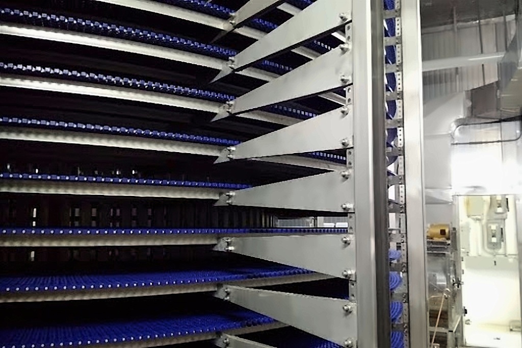 Multi tier spiral freezer belt stack in freezing enclosure